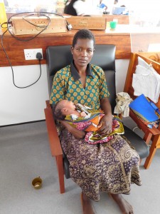 A woman posing with her grandchild in Chatinkha. The child's mother is in the ICU at QECH. 